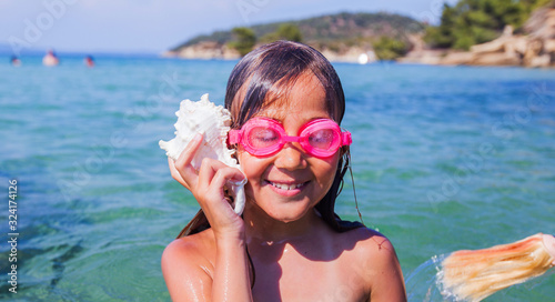 Happy little girl with the seashell