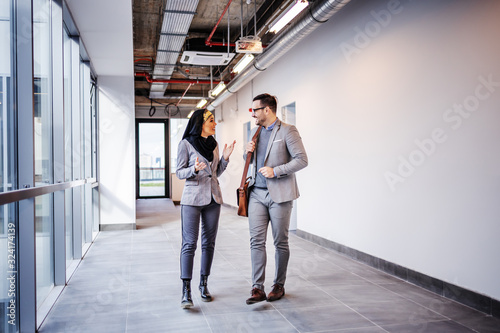 Canvas Print Real estate agent walking and talking with female arab investor about building she want to buy