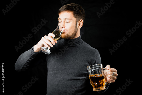 a man with a beer in his hand drinking champagne from a glass, a choice of alcoholic beverage photo