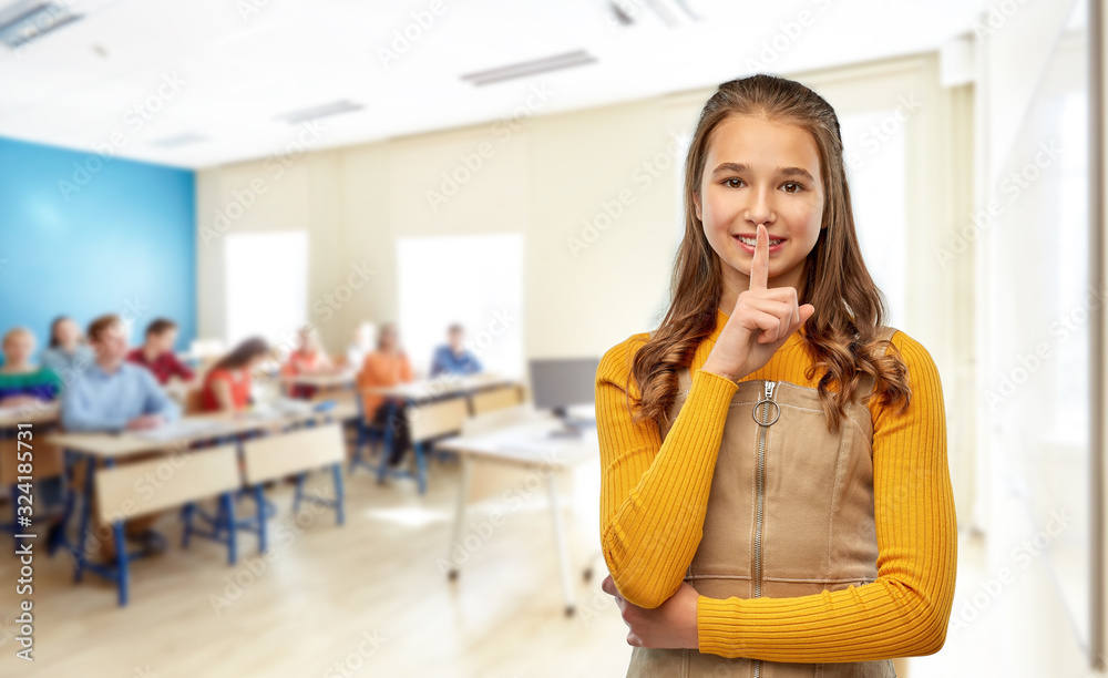 school, education and learning concept - young teenage student girl making hush gesture over classroom background