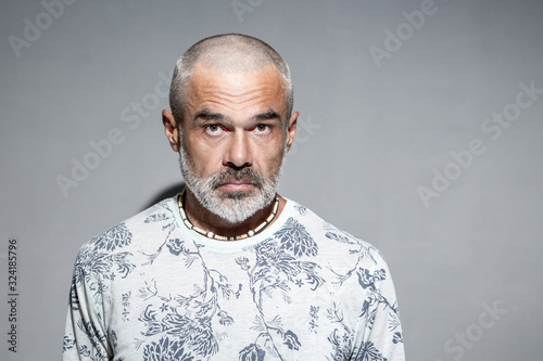 Fotografija Serious mature man with short shaved head hairstyle looking fiercely