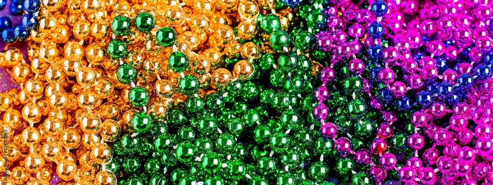 Carnival shiny beads, traditional carnaval accessories. Mardi gras beads macro background, copy space, top view Carnival shiny beads, traditional carnaval accessories. Mardi gras beads macro background, copy space, top view