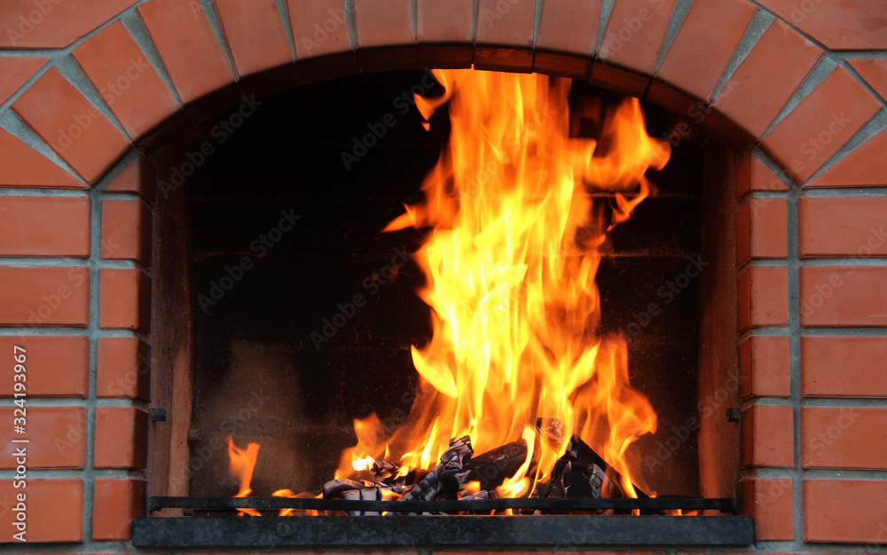 Obraz premium Fireplace Of Brick Oven With Burning Logs