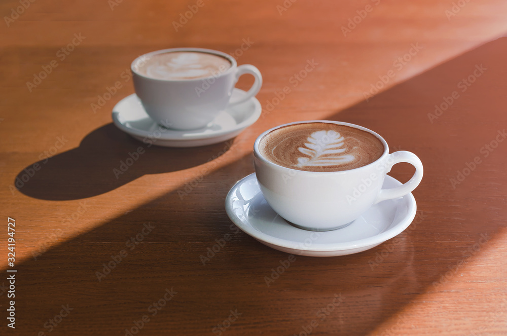 Obraz premium Two morning cups of coffee on wooden background