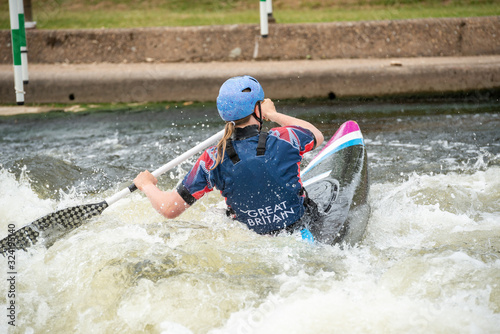 C1W class GB Canoe Slalom Athlete in white water action paddling away from camera
