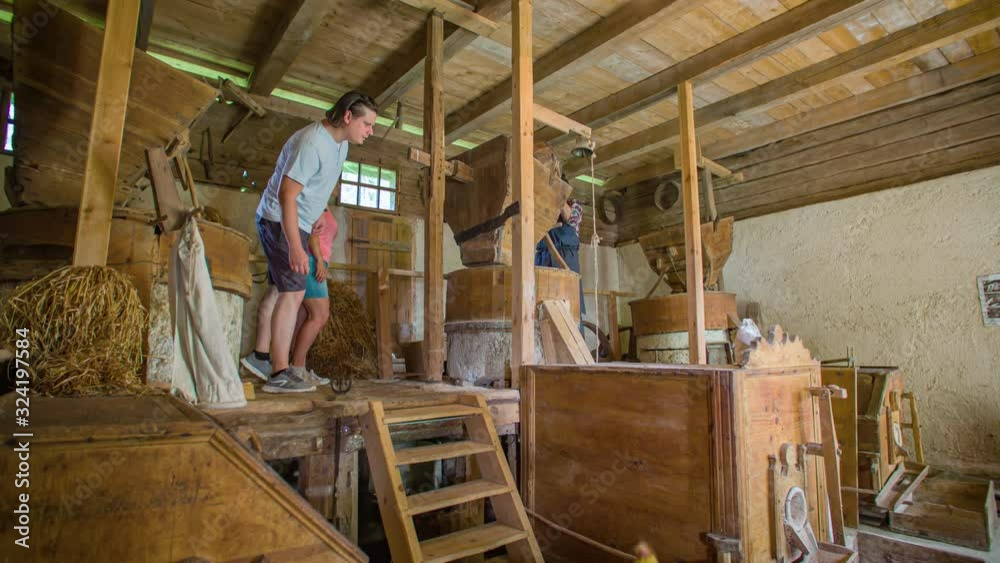 Young Couple Exploring Inside Of Wheat Mill Watching Farmer Work. Slow Motion Young Couple Exploring Inside Of Wheat Mill Watching Farmer Work. Slow Motion