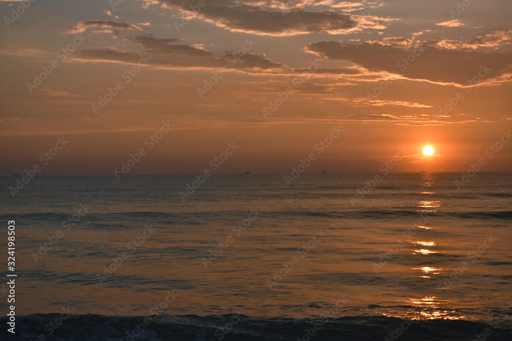 Obraz premium A beautiful evening in a beach with a sunset into a ocean