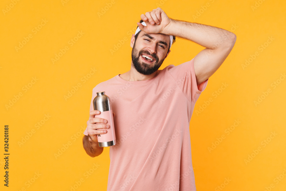 Image of tired athletic young man in t-shirt holding water bottle Image of tired athletic young man in t-shirt holding water bottle