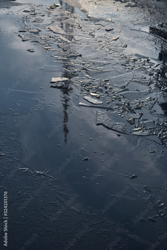 the TV tower is reflected in an icy puddle