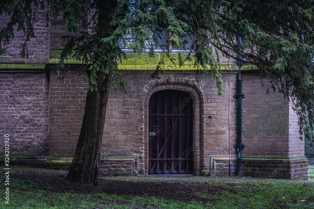 An old wooden church door covered with steel bars in a park in Deventer, Netherlands An old wooden church door covered with steel bars in a park in Deventer, Netherlands