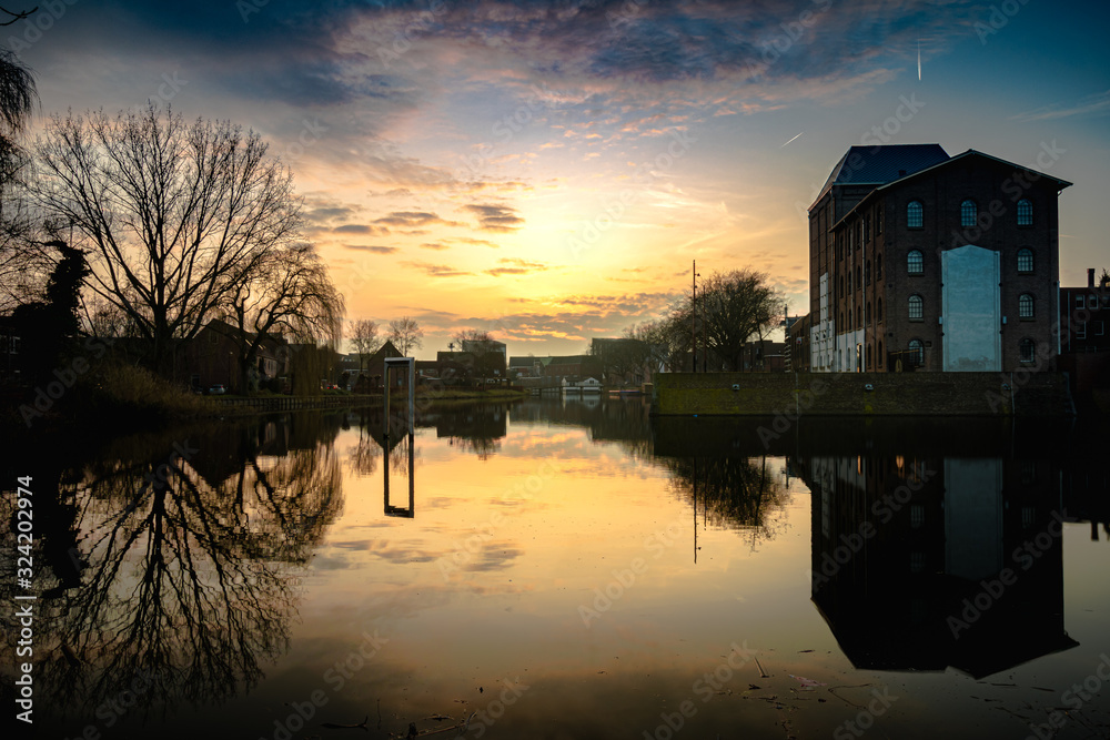 Fototapeta premium An old industrial building on a pond during the sunset in Deventer, the Netherlands