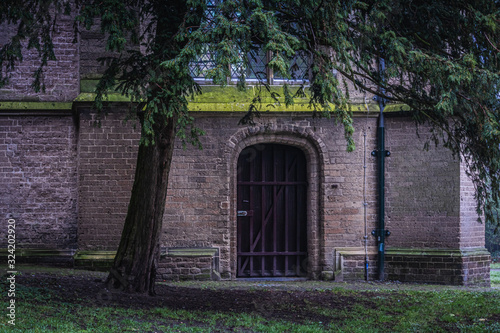 An old wooden church door covered with steel bars in a park in Deventer, Netherlands