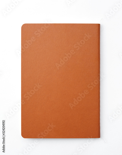 Top view of closed stitch blank recycled paper cover notebook on white background. © RooftopStudioBangkok