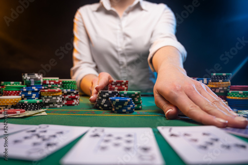 Playing cards in a casino. A lot of chips, money. A player in a casino makes bets. Poker