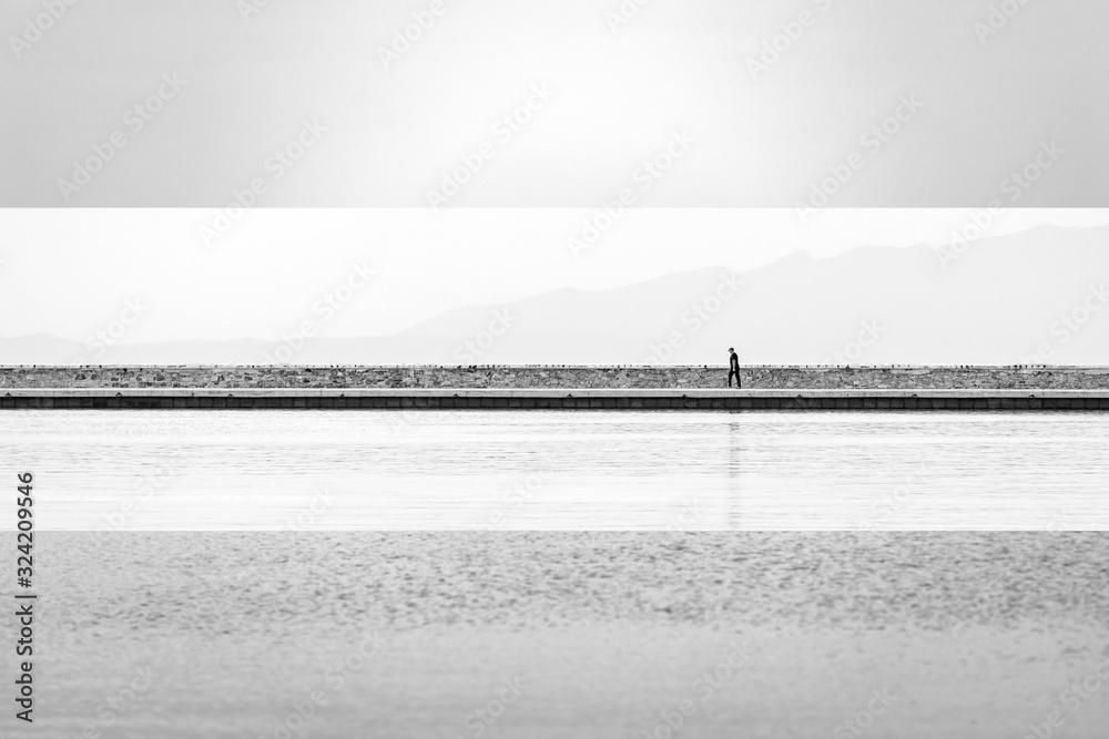 Lonely man walking on the sea shore. Mosaic image.