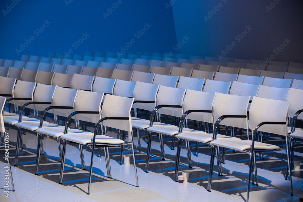 Naklejka premium White chairs in a conference hall perfectly aligned