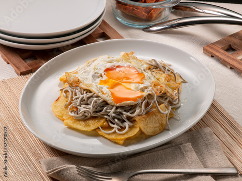 Tableau sur toile huevos rotos con gulas y patatas