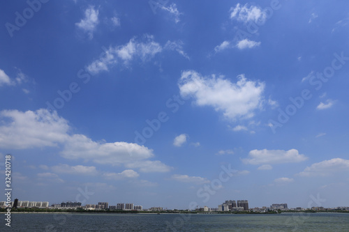 A coastal city under the blue sky and white clouds  beautiful clouds in the vast sky © Wheat field