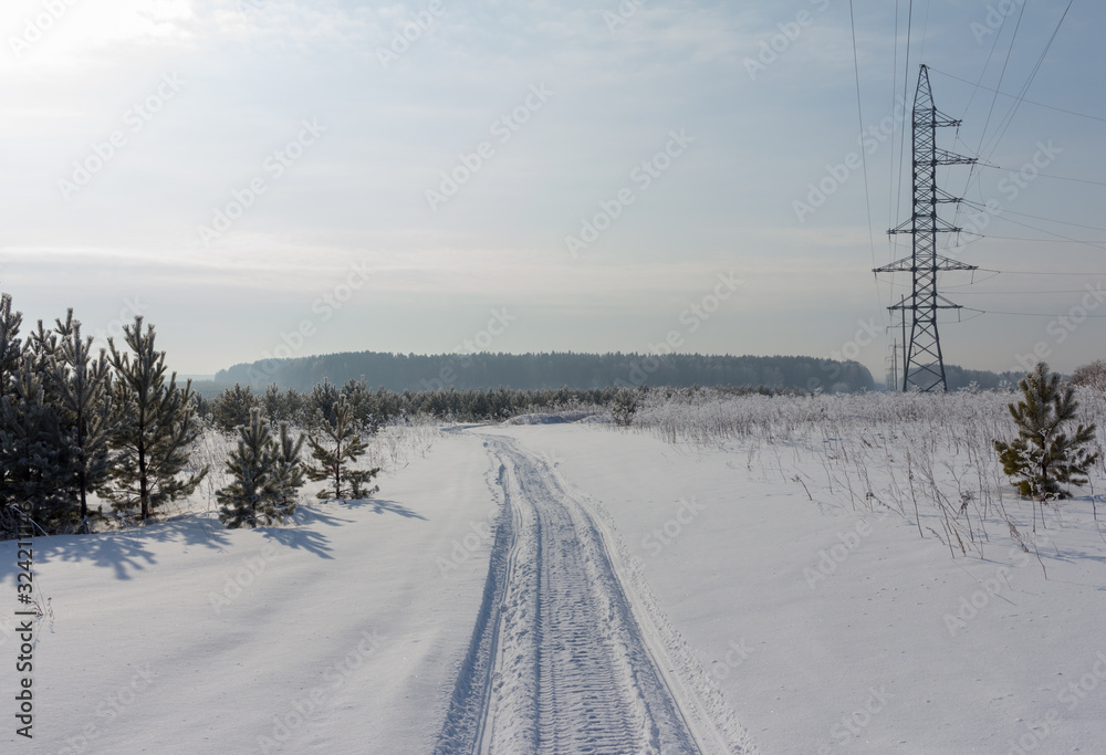 Fototapeta premium snowmobail trail at field covered by snow
