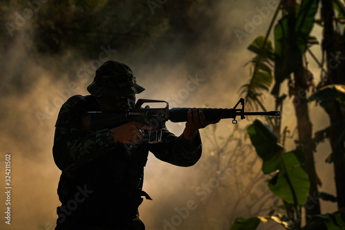 Special forces soldier with rifle, Low-key lighting.