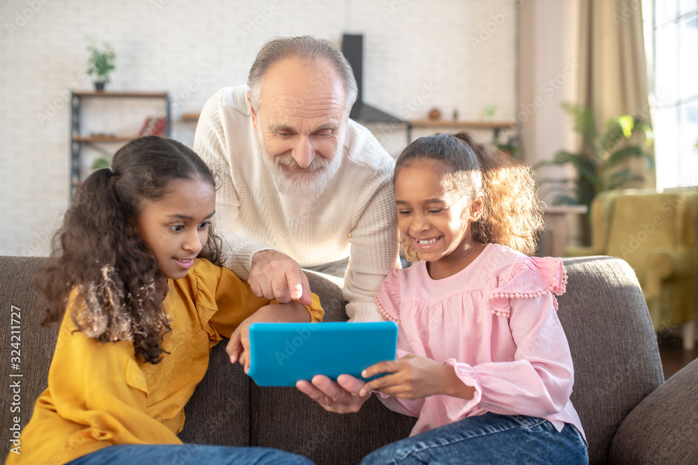 Bearded man in a white shirt pointing to the tablets screen Bearded man in a white shirt pointing to the tablets screen