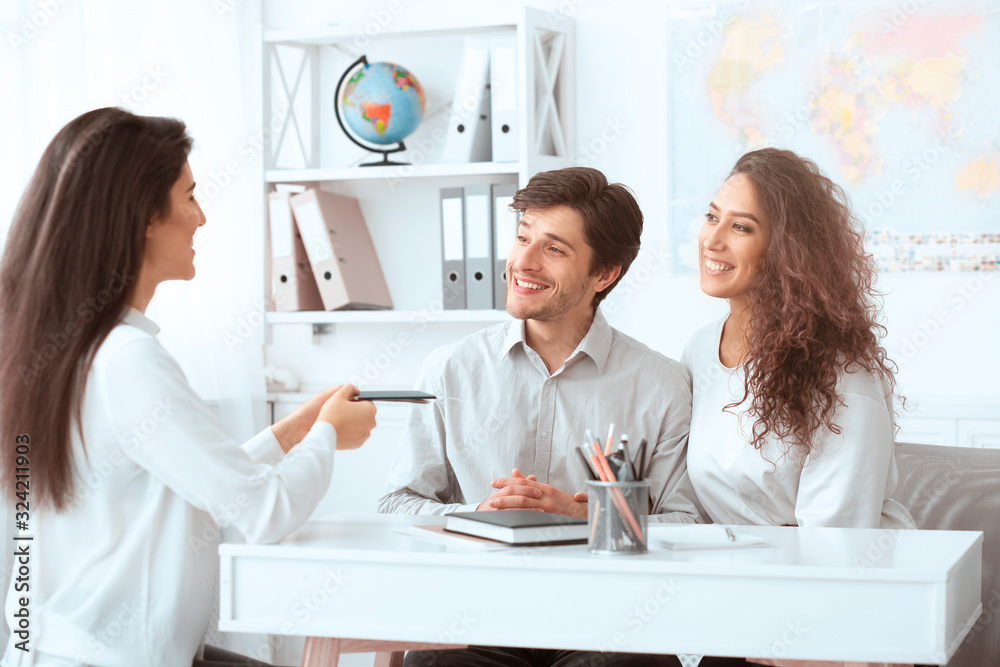 Happy holidays Travel agent giving tickets to couple Happy holidays Travel agent giving tickets to couple
