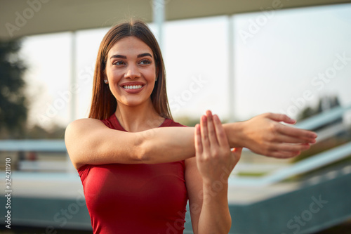 Young woman exercising / stretching in urban park. Free Download Young woman exercising / stretching in urban park. - GFXLoad
