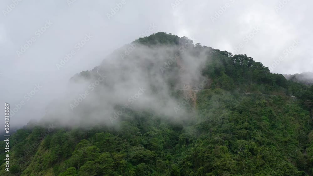 Mountain peaks are covered with rainforest and clouds. Jungle in the highlands on Luzon Island, Philippines. rainforest on the top of a mountain covered with fog in the morning. Rain clouds in a Mountain peaks are covered with rainforest and clouds. Jungle in the highlands on Luzon Island, Philippines. rainforest on the top of a mountain covered with fog in the morning. Rain clouds in a