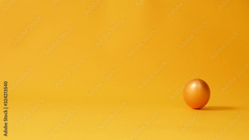 Chicken gold easter egg spinning on yellow background. Happy Easter Concept