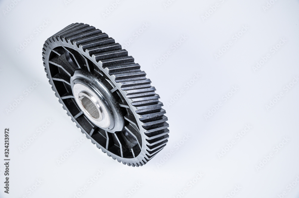 Black polymer gear camshaft with metal base. New spare part for an internal combustion engine on a gray background Black polymer gear camshaft with metal base. New spare part for an internal combustion engine on a gray background