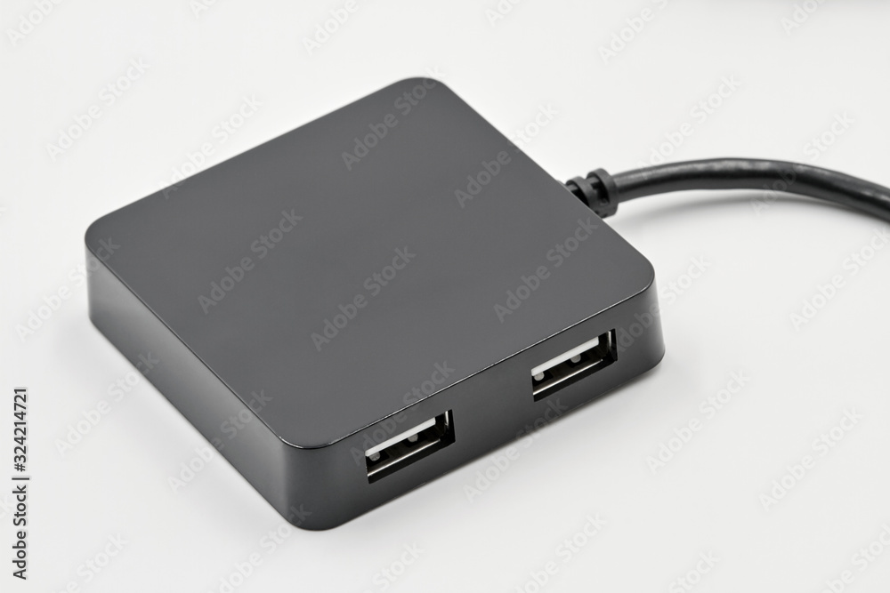 Black portable USB hub for four connections on a white background. Bus povered. Closeup, selective focus Black portable USB hub for four connections on a white background. Bus povered. Closeup, selective focus