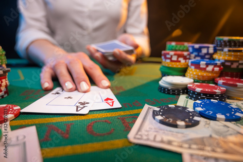 a croupier or a dealer works. A game of cards in a casino. A lot of chips, money. A player in a casino makes bets. Poker
