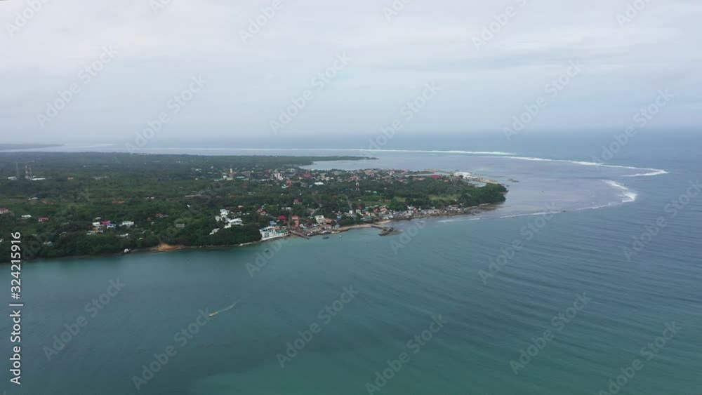 Seascape. Town with hotels and a pier on the island, aerial view. The city of Bolinao, the island of Luzon. Landscape with a big island. Summer and travel vacation concept. Seascape. Town with hotels and a pier on the island, aerial view. The city of Bolinao, the island of Luzon. Landscape with a big island. Summer and travel vacation concept.