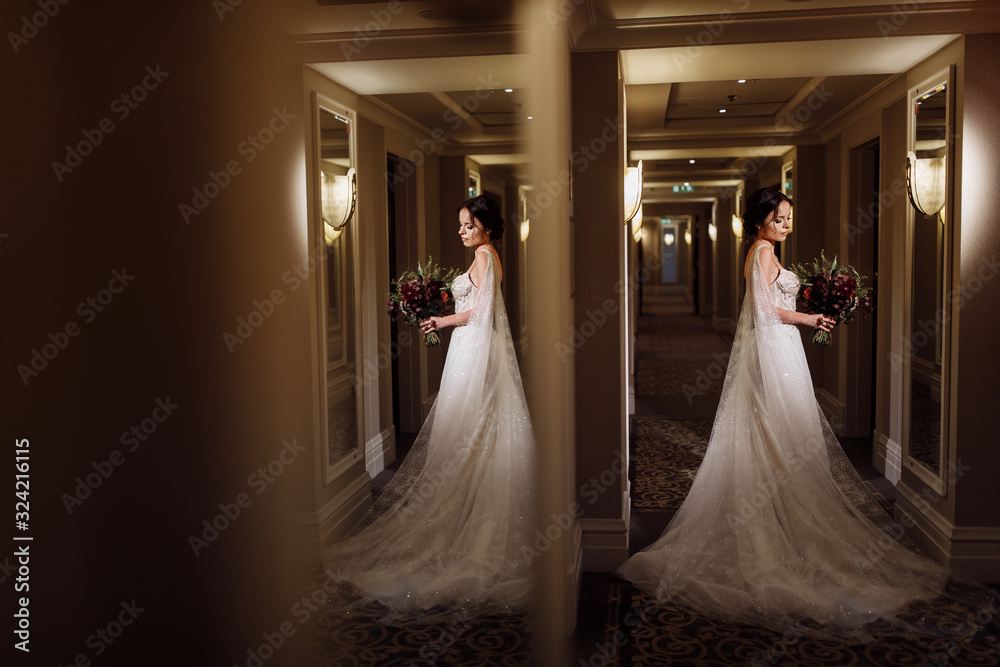 Portrait of beautiful bride with red bouquet in the hall