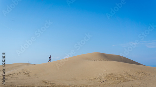 adventurer walking on a dune in a desert