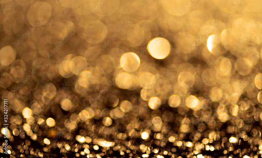Gold glitter particles background. Sparkling light boke blur. Template for christmas theme.