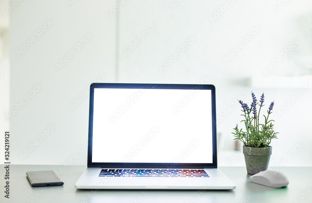 Laptop with blank screen on white table with mouse and smartphone. Home interior or office background Laptop with blank screen on white table with mouse and smartphone. Home interior or office background