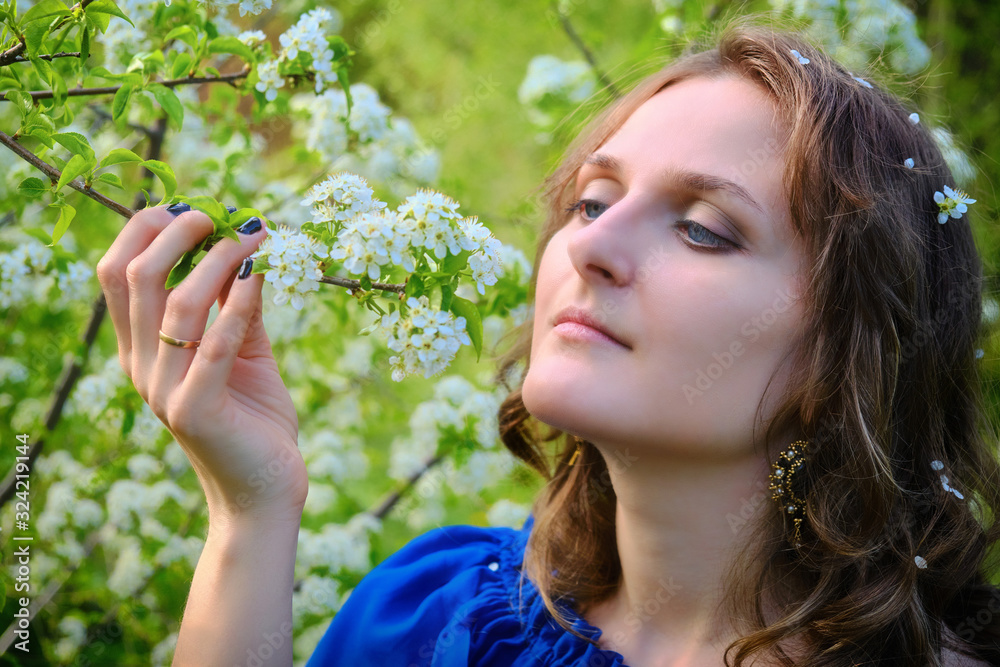 A woman with a branch of a flowering tree in her hands A woman with a branch of a flowering tree in her hands