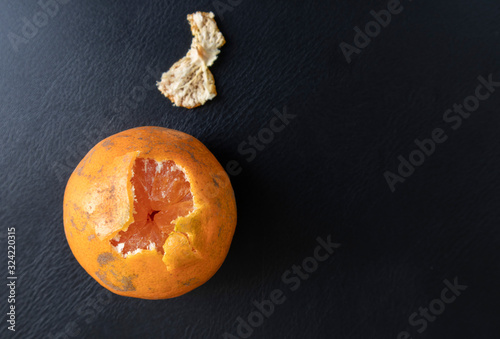 Top view, orange peeled by hand, placing on floor. Healthy fresh orange.Design isolated on black. Healthy diet concept. Peeled oranges placed on black floor. Concept differenc in same place photo