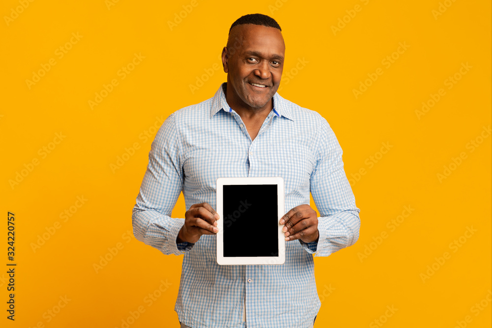 Smiling middle aged african man showing blank digital tablet Smiling middle aged african man showing blank digital tablet