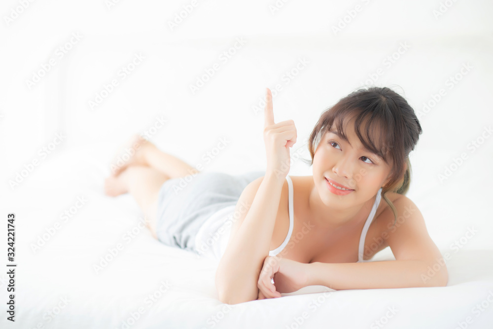 Portrait beautiful young asian woman smile wake up healthy and wellness at morning, beauty asia girl lying and pointing something skin care and makeup cosmetic with happy, lifestyle and relax concept. Portrait beautiful young asian woman smile wake up healthy and wellness at morning, beauty asia girl lying and pointing something skin care and makeup cosmetic with happy, lifestyle and relax concept.
