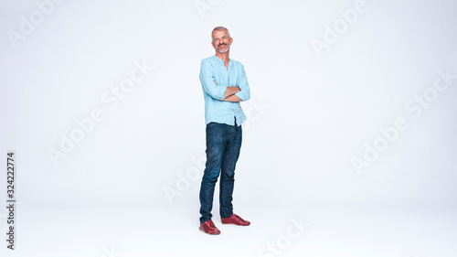 Senior man standing with arms crossed photo