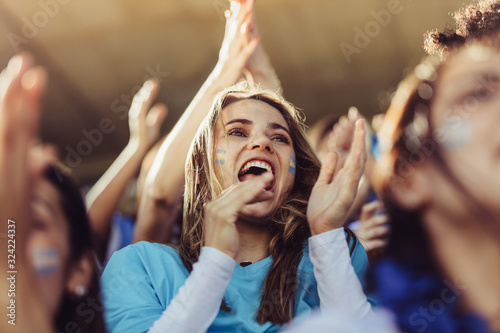 Fototapeta Naklejka Na Ścianę i Meble -  Group of Argentinian soccer fans cheering in stands