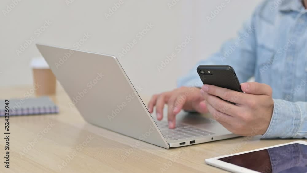 Man using Laptop with Smartphone, Close up Man using Laptop with Smartphone, Close up