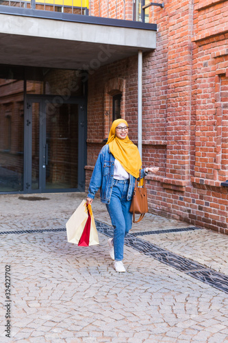 Sale and buying concept - Happy arab muslim girl with shopping bags after mall © satura_