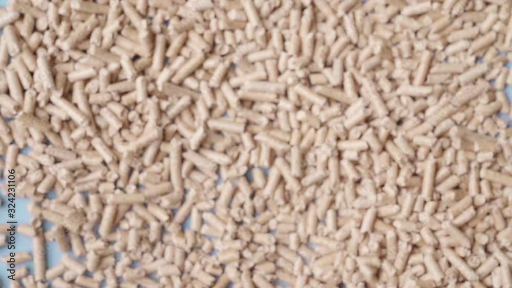 Slow motion,Top view shot of pallet fuel spread on blue background flat lay, jumping / exploding towards the camera  , eco sustainability bio fuel icons, home bills saving money house heating ideas.