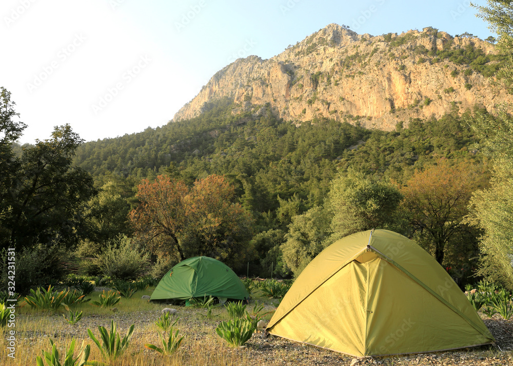 Tourist tents on camping meadow in mountains