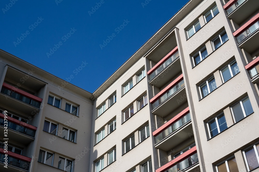 Blocks of flats and house with apartments - residential building windows and balconies. Clear blue sky.