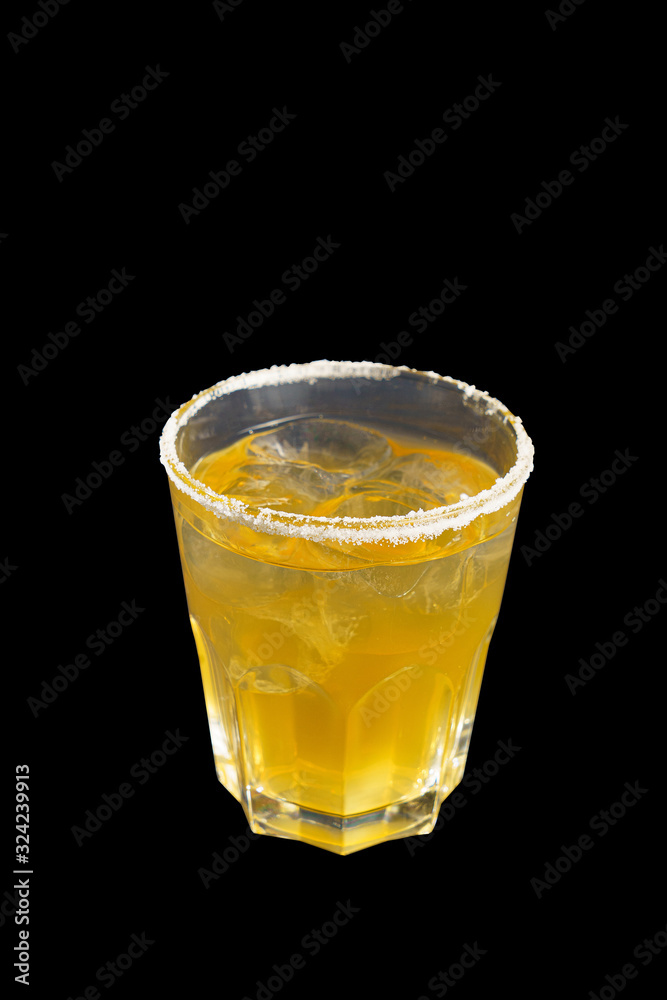 A yellow transparent cocktail in a low glass with ice cubes, with the taste of apricot, pineapple with sugar, Side view, Isolated black background, Drink for the menu restaurant, bar, cafe A yellow transparent cocktail in a low glass with ice cubes, with the taste of apricot, pineapple with sugar, Side view, Isolated black background, Drink for the menu restaurant, bar, cafe