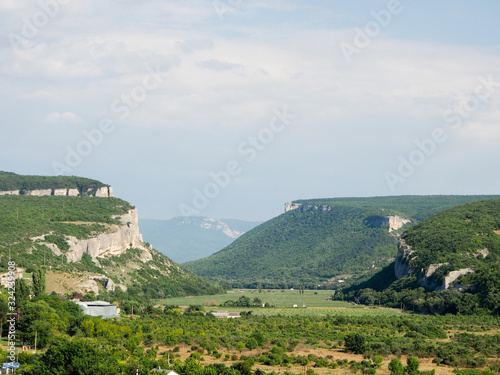 Kachinsky canyon tract of Crimea, mountain landscape in the area of Bakhchisaray. View of the village of Tankovoe and the mountains in the Mangup-Kale area. photo